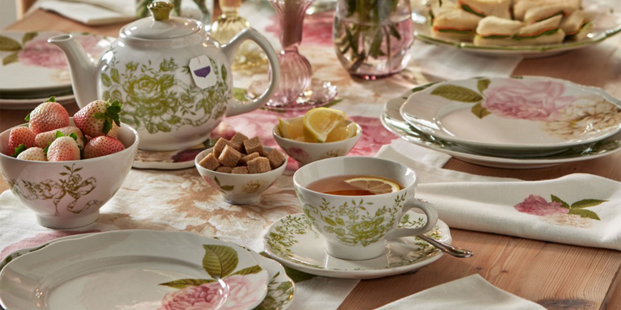 Tea set with teacup, teapot, and plates on a table with pastel colors